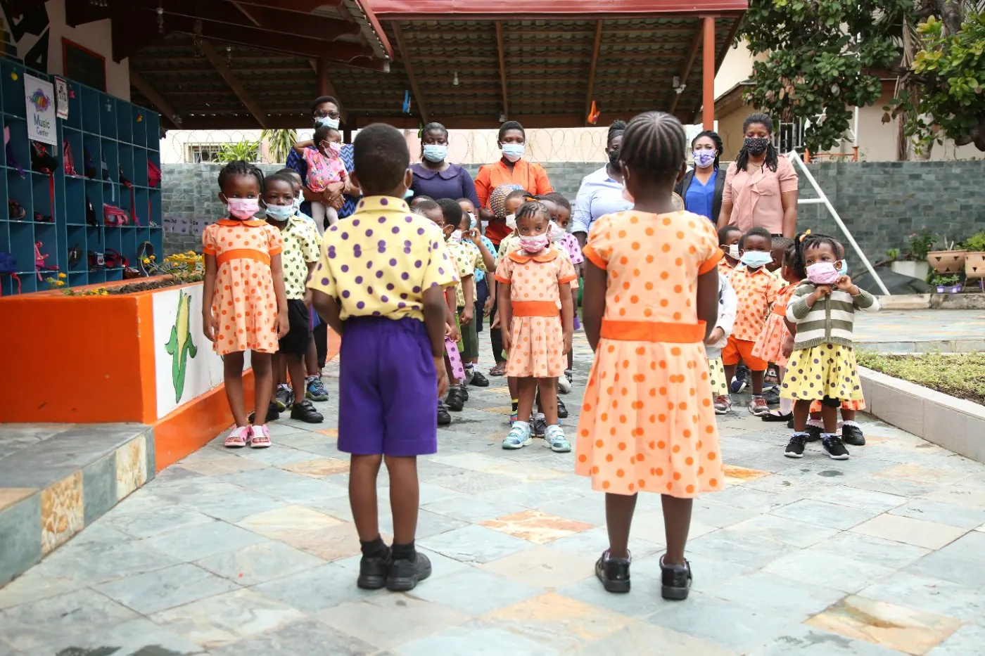 Children in polka-dot uniforms lining up in the Early Starters courtyard