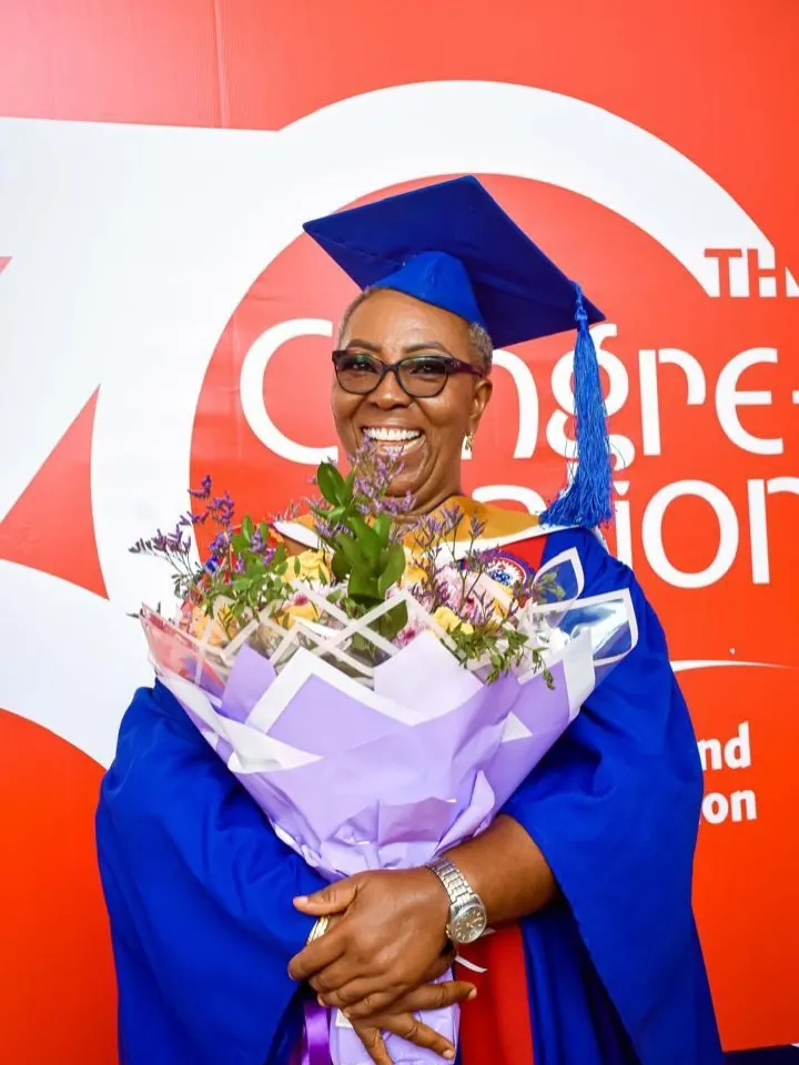 Lynda Odro in graduation gown holding flowers at the University of Education, Winneba