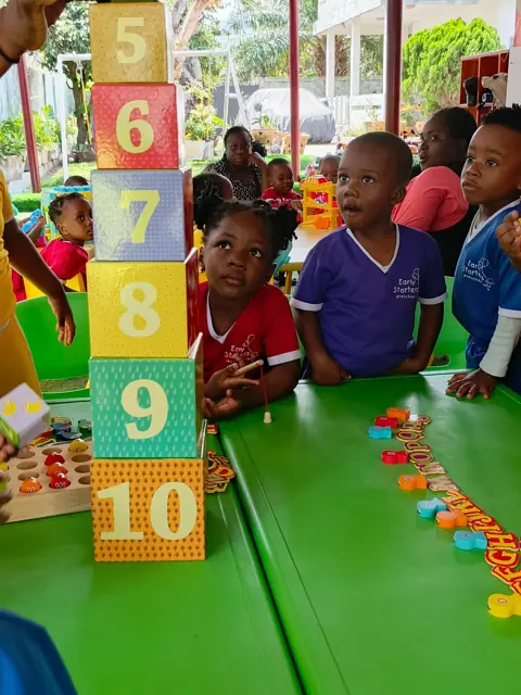 Children watching a tower of number blocks being built